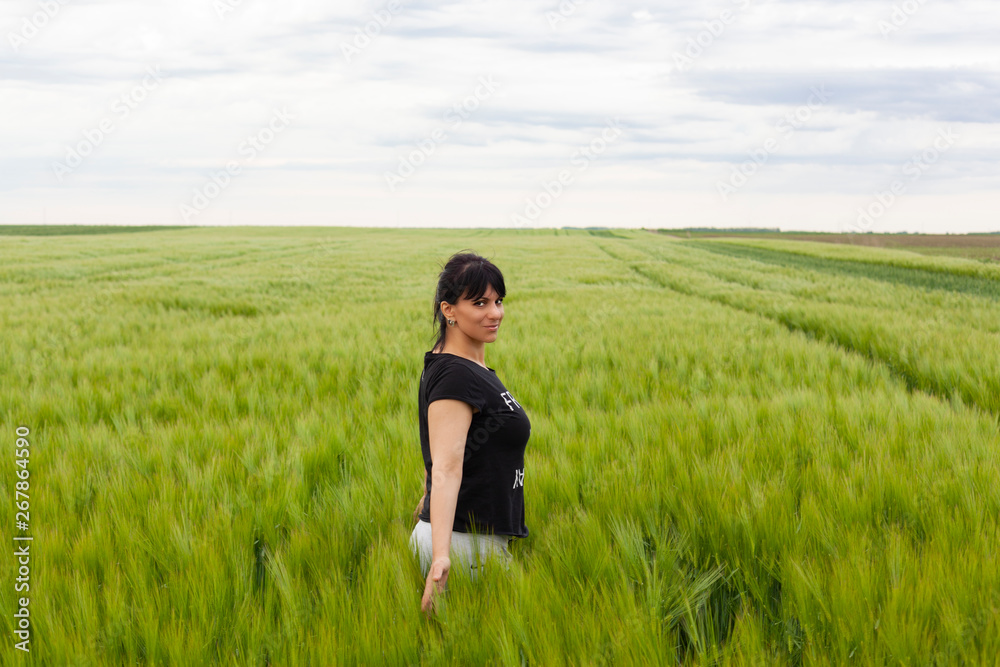 beautiful girl posing in the grain field on a sunny day