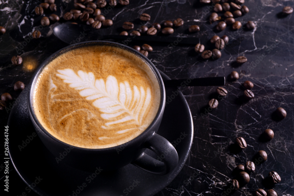 Cup of cappuccino coffee on dark table with coffee beanss Cup of cappuccino coffee on dark table with coffee beanss