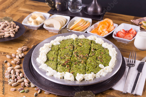 Turkish dessert kunefe  kunafa  kadayif with pistachio powder and cheese hot eaten a sweet