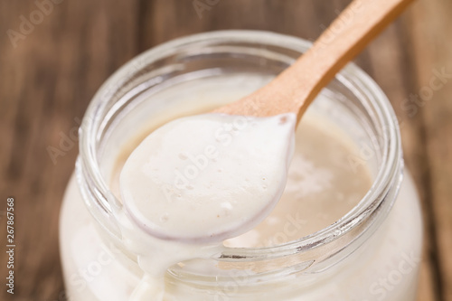 Fresh homemade bubbly sourdough starter, a fermented mixture of water and flour to use as leaven for bread baking (Selective Focus, Focus one third into the spoon)