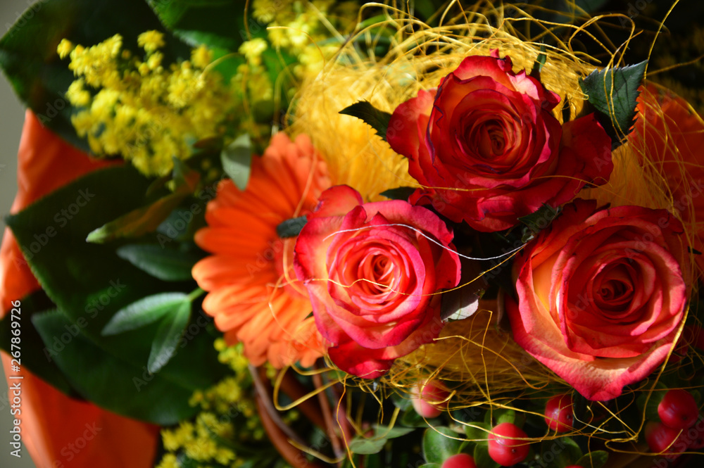 bouquet of roses with orange gerberas and yellow mimosa.