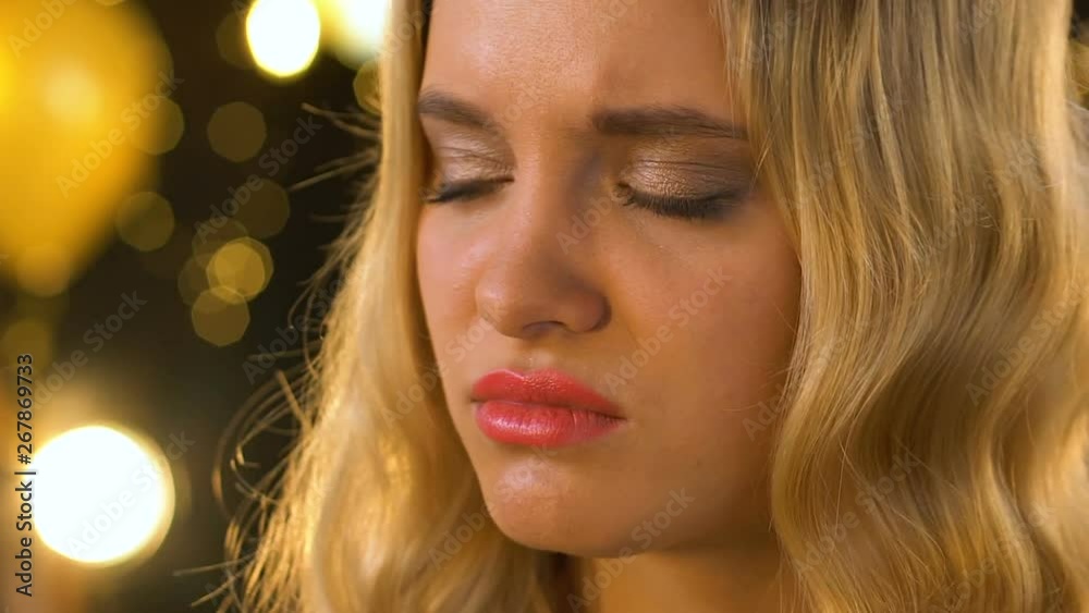 Irritated lonely blond female feeling jealous at party and drinking champagne Irritated lonely blond female feeling jealous at party and drinking champagne