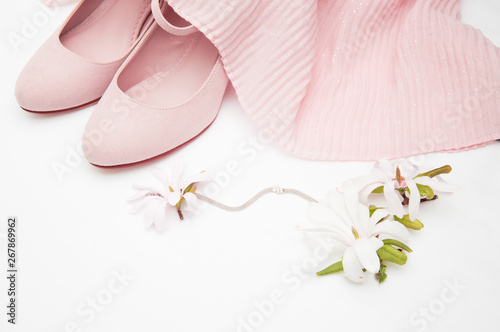 Fototapeta Naklejka Na Ścianę i Meble -  gently beige clothes for girls with a delicate taste of style, on a white background with beautiful magnolia flowers