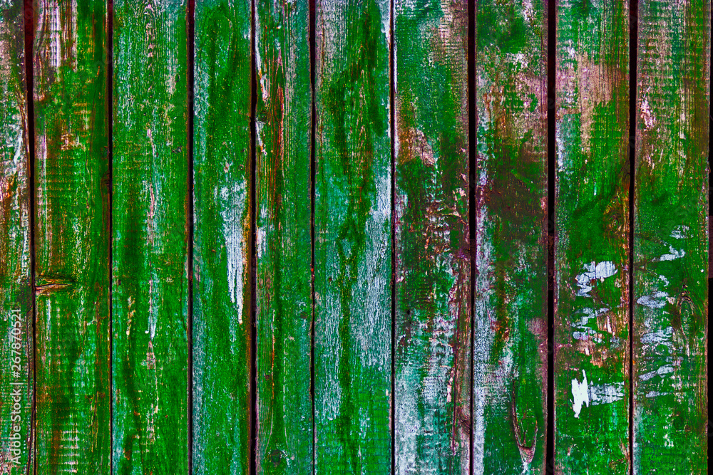 Fototapeta premium Freen painted Rural wooden fence with peeling paint