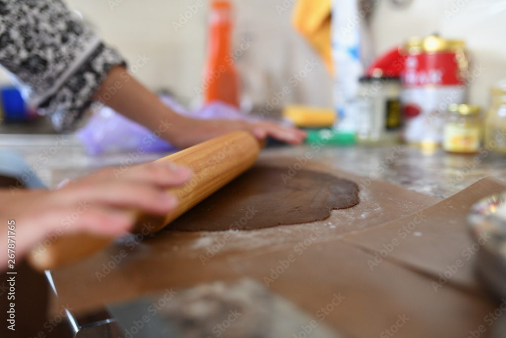 Mom rolls the dough. chocolate dough. Hands work with cake dough recipe preparation. Women's hands, Women's hands roll out the dough. Mom rolls dough on a kitchen board with a rolling pin Mom rolls the dough. chocolate dough. Hands work with cake dough recipe preparation. Women's hands, Women's hands roll out the dough. Mom rolls dough on a kitchen board with a rolling pin