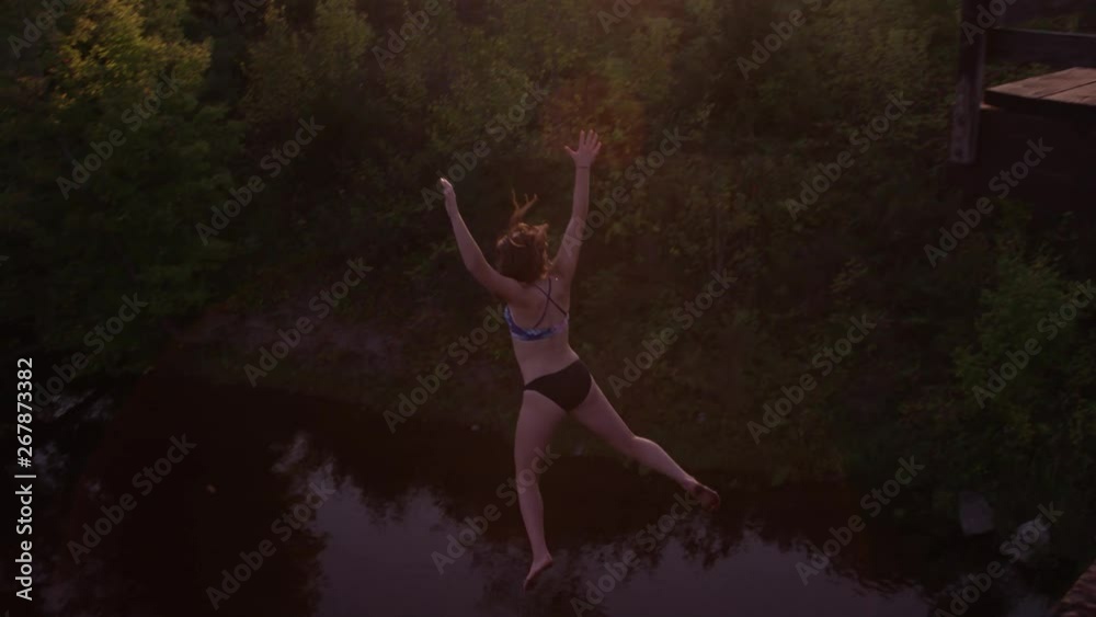 Woman jumping off of bridge into water fun diving extreme travel ...
