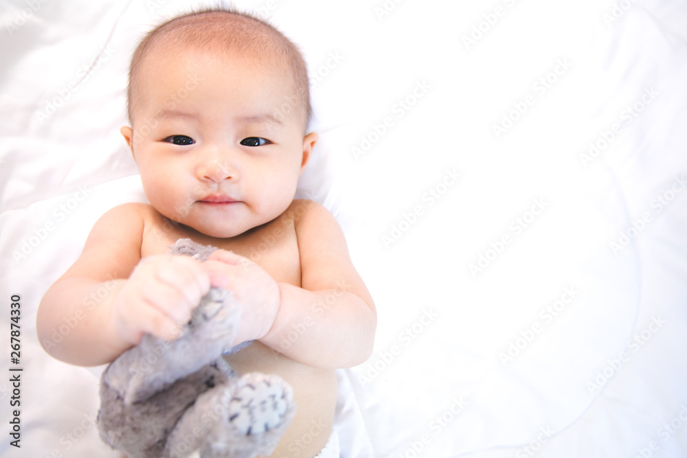 Asian baby happy in the room.Asian baby girl lying down on bed . Asian baby happy in the room.Asian baby girl lying down on bed .