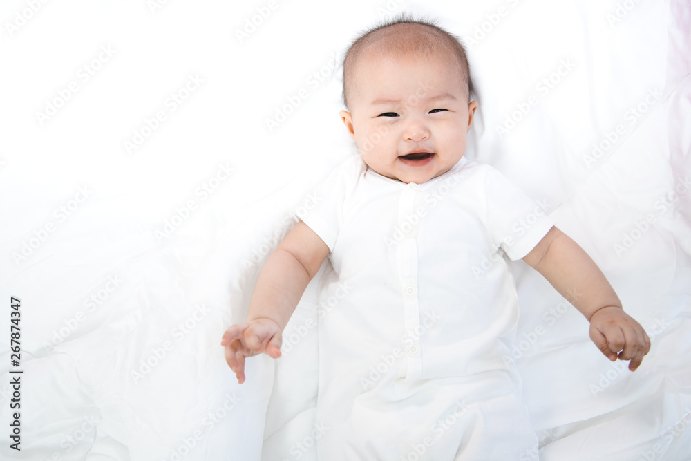 Asian baby happy in the room.Asian baby girl lying down on bed . Asian baby happy in the room.Asian baby girl lying down on bed .