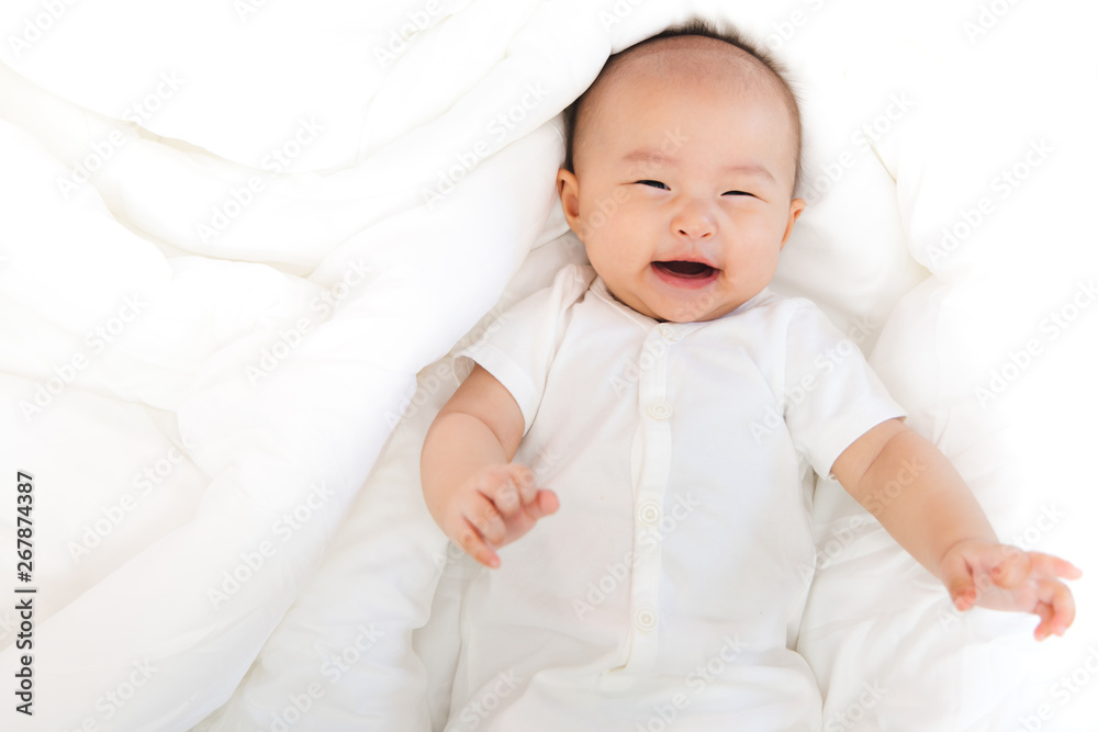 Asian baby happy in the room.Asian baby girl lying down on bed . Asian baby happy in the room.Asian baby girl lying down on bed .
