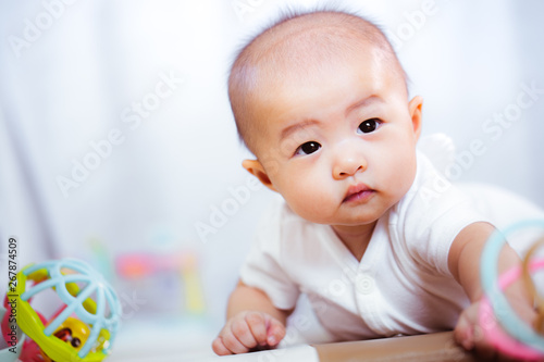 Asian baby happy in the room.Asian baby girl lying down on bed .