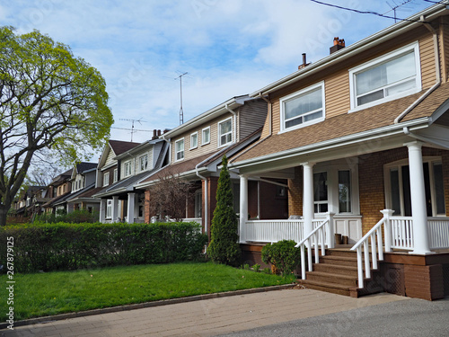 Photography row of small detached houses with full width porch