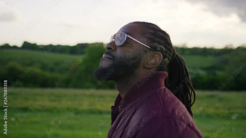 Young casual black male walking through the countryside, in slow motion Young casual black male walking through the countryside, in slow motion