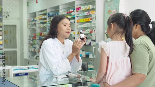 Beautiful asian Pharmacist explaining the medication to patient in drug store