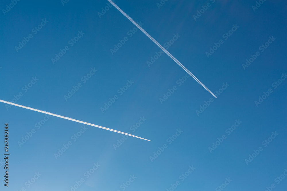 Two planes with traces on a blue sky background. Two planes with traces on a blue sky background.