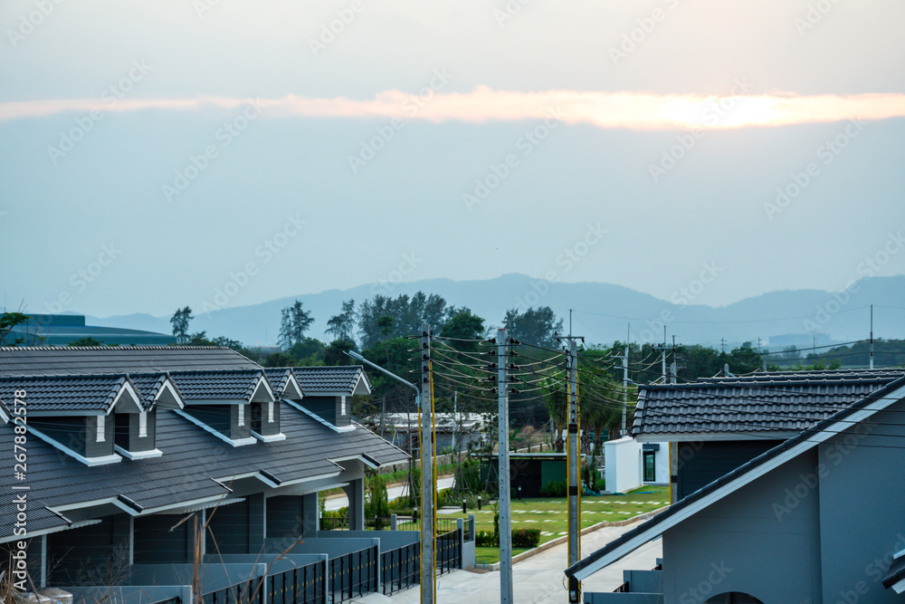 Fototapeta premium Top view roof of modern village with sunset sky, New modern town home style, Beautiful house in dawn sky, Born of new home village show of expansion of business background concept