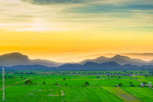 Beautiful sky and landscape of rice field view of countryside in evening of Thailand and many mountain in background.