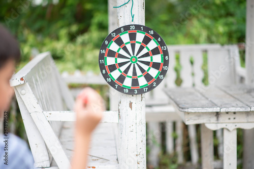 Little boy playing darts board family outdoor activity photo