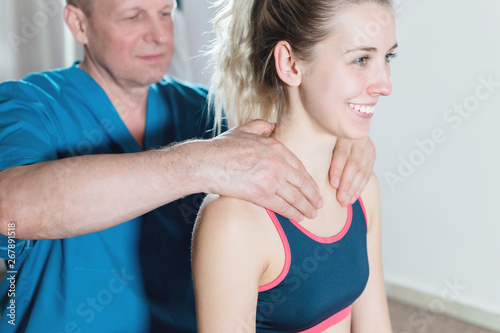 Male manual visceral therapist masseur treats a young female patient. Warm up the shoulders and neck