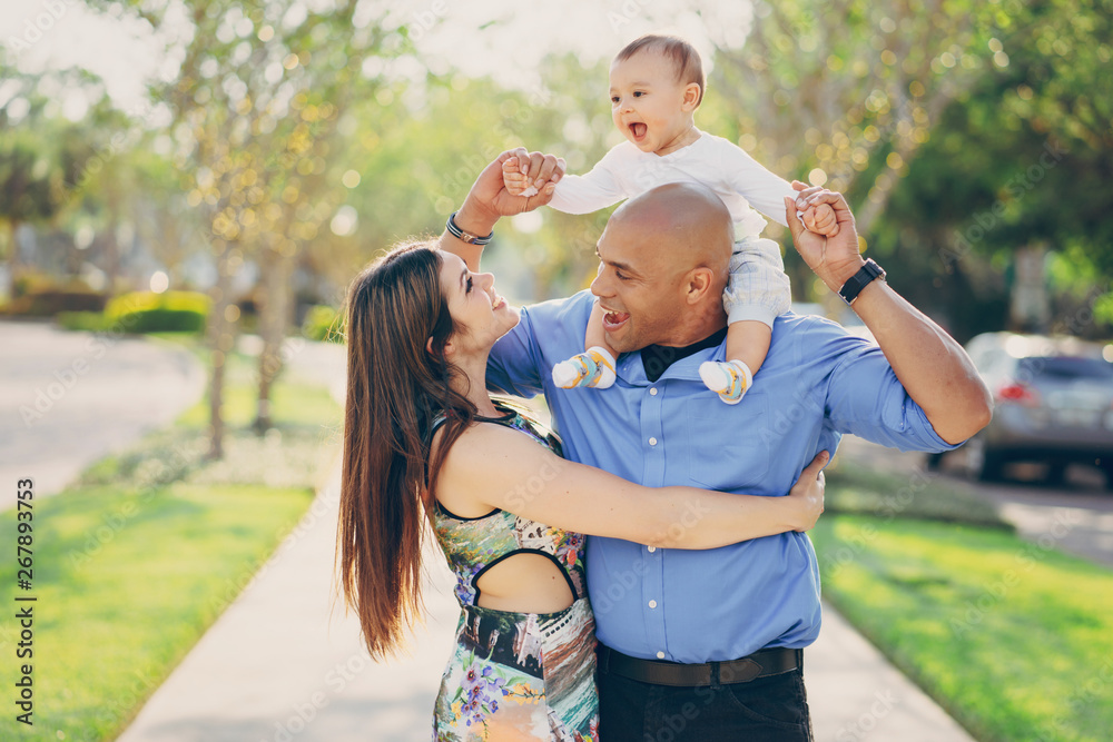 Fototapeta premium mom and dad a wonderful little son walking in summer sunny city