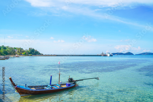 boat floating on turquoise sea with bright blue sky in Phuket province, Thailand