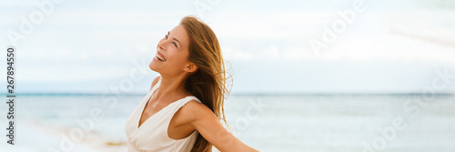 Happy Asian woman feeling good and free on ocean banner background on beach travel vacation cruise panorama.