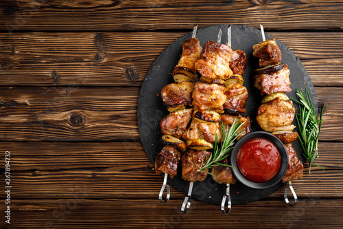 Grilled meat skewers, shish kebab on wooden background, top view