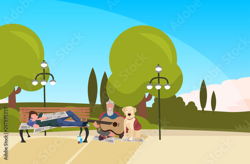 bearded man tramp sitting with dog playing guitar drunk beggar lying on wooden bench outdoor homeless jobless concept city park landscape background horizontal full length