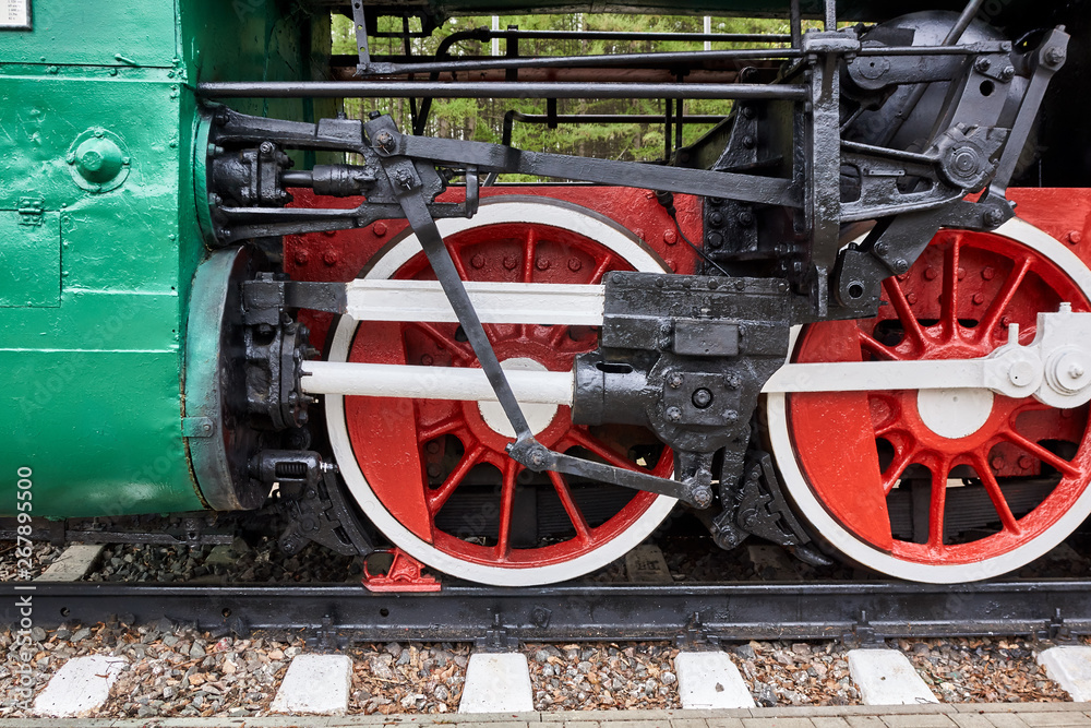 Steel wheels old steam locomotive standing on rails, vintage train, close-up