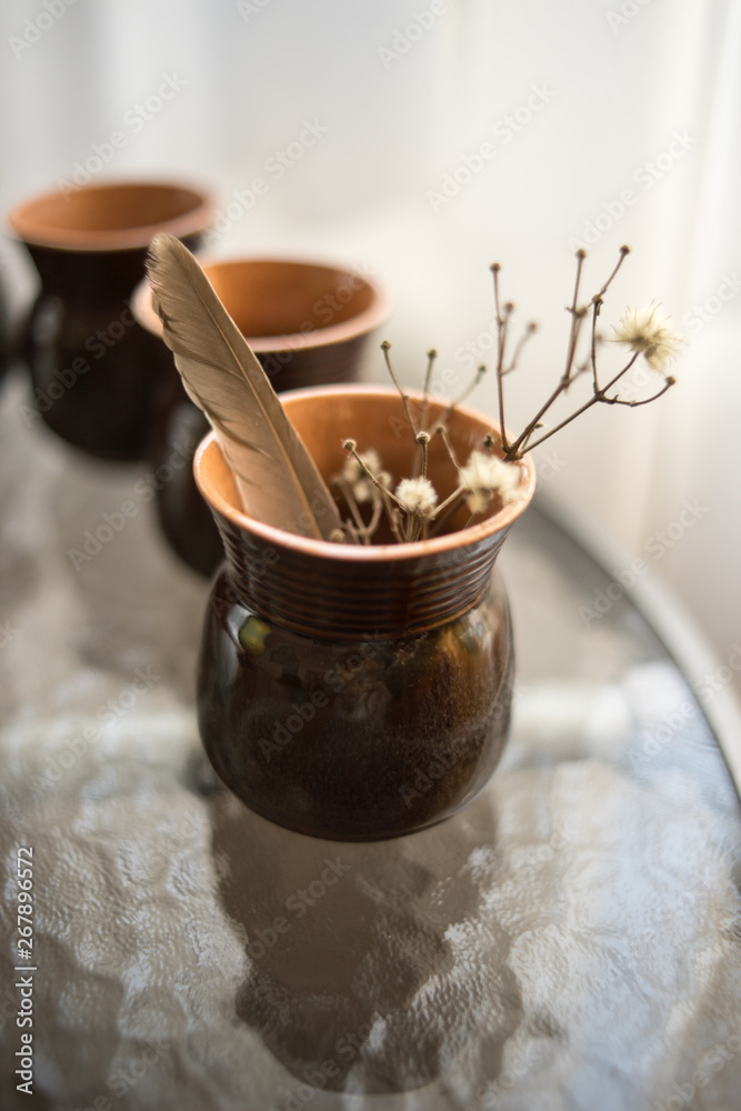 Dry flowers and feather in ceramic vase Dry flowers and feather in ceramic vase