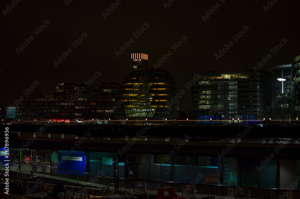 London river thames at night with glowing lights on buildings