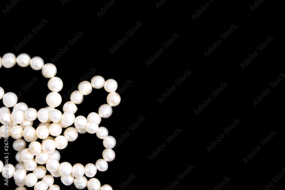White pearls necklace on black background White pearls necklace on black background