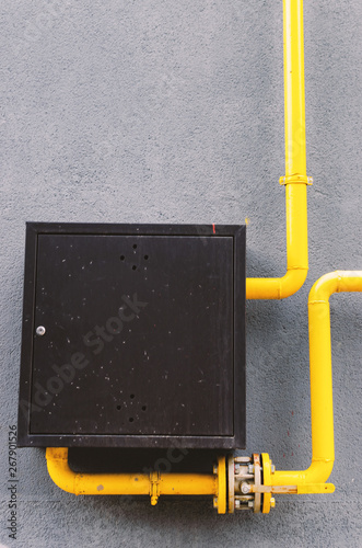 yellow gas pipe with a crane goes along the facade of a new multi-storey building.