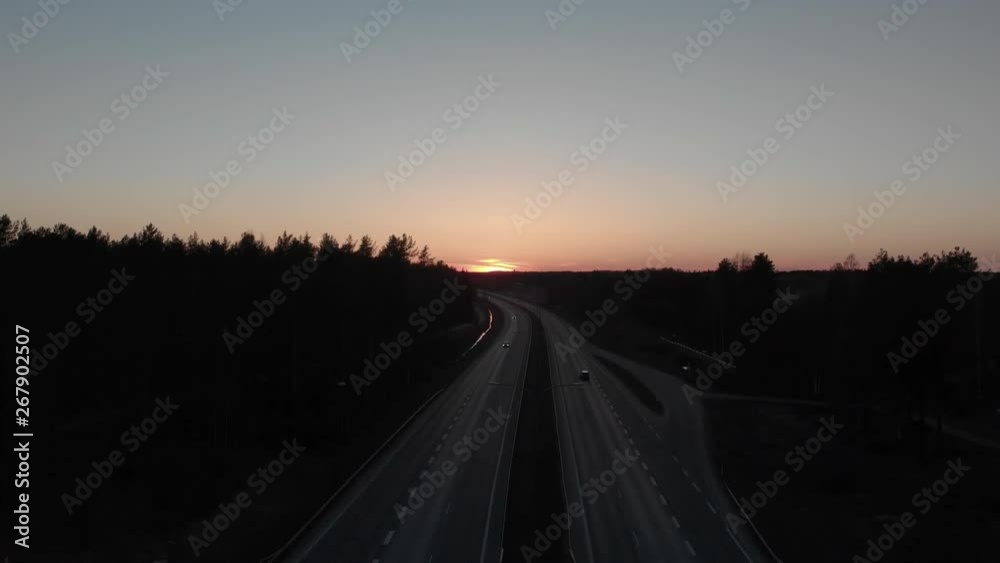 Aerial, rising, drone shot, of traffic on a motorway, at sunset, on a spring evening dusk, in Joensuu, North Karelia, Finland Aerial, rising, drone shot, of traffic on a motorway, at sunset, on a spring evening dusk, in Joensuu, North Karelia, Finland