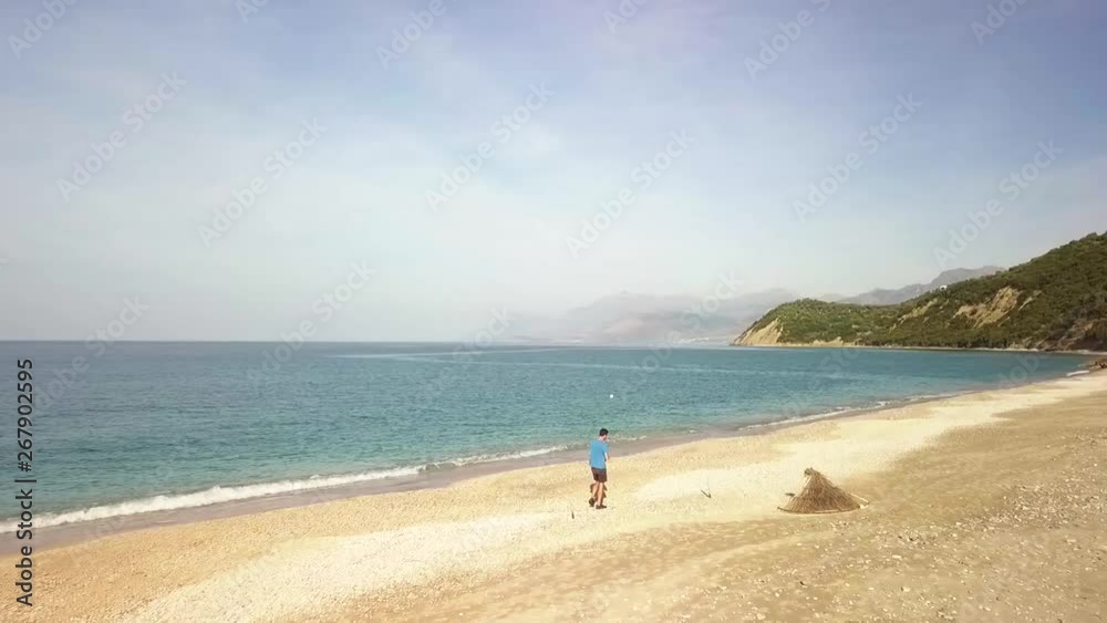 Human walking along Lukova Beach on the Albanian Riviera during a summer vacation in Albania. Beautiful coastline in the Balkans in the Adriatic Sea Human walking along Lukova Beach on the Albanian Riviera during a summer vacation in Albania. Beautiful coastline in the Balkans in the Adriatic Sea