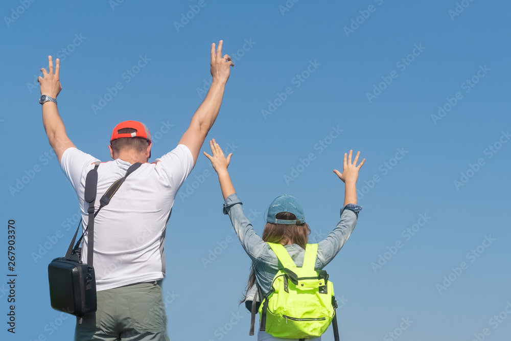 Happy dad and daughter with raised hands look at the sky. Concept of happy father day. Happy dad and daughter with raised hands look at the sky. Concept of happy father day.