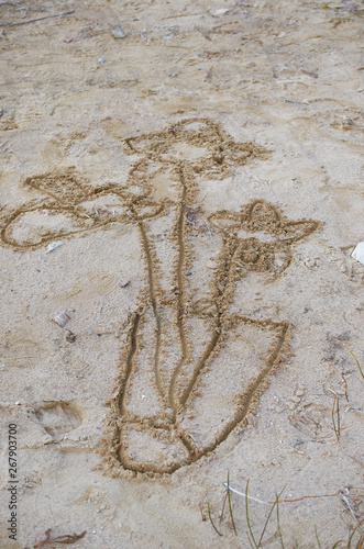 children drawing in sand with bouquet of flowers in a vase