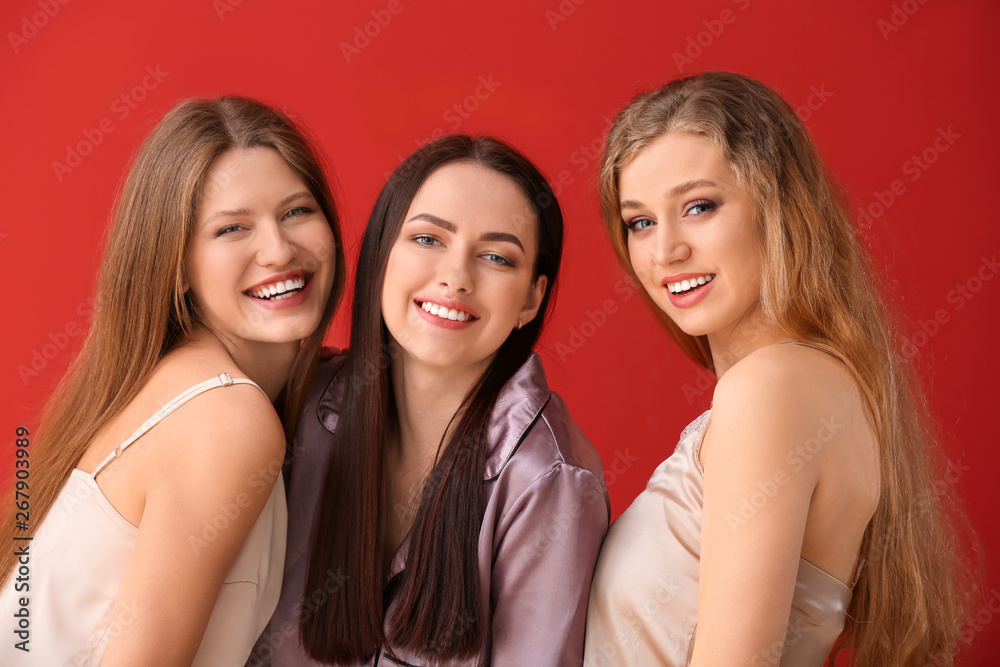 Beautiful young women in pajamas on color background Beautiful young women in pajamas on color background
