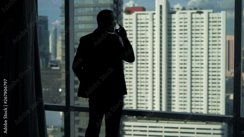 Young businessman drinking and admire view from window at office Young businessman drinking and admire view from window at office