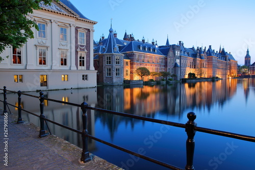 Reflections of the Mauritshuis and the Binnenhof (13 century gothic castle) on the Hofvijver lake during the blue hour, with the clock tower of Grote of Sint Jacobskerk, The Hague, Netherlandsl