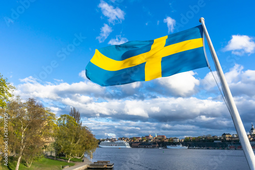 Photography Swedish flag against blue sky with white clouds