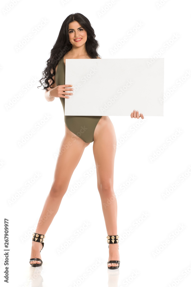 Attractive brunette with blank board in one piece swimsuit on white background Attractive brunette with blank board in one piece swimsuit on white background