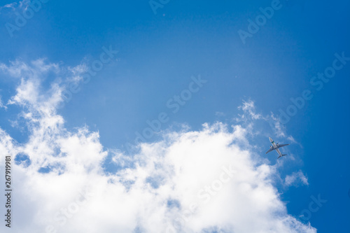 Flying plane on a background of blue sky and clouds