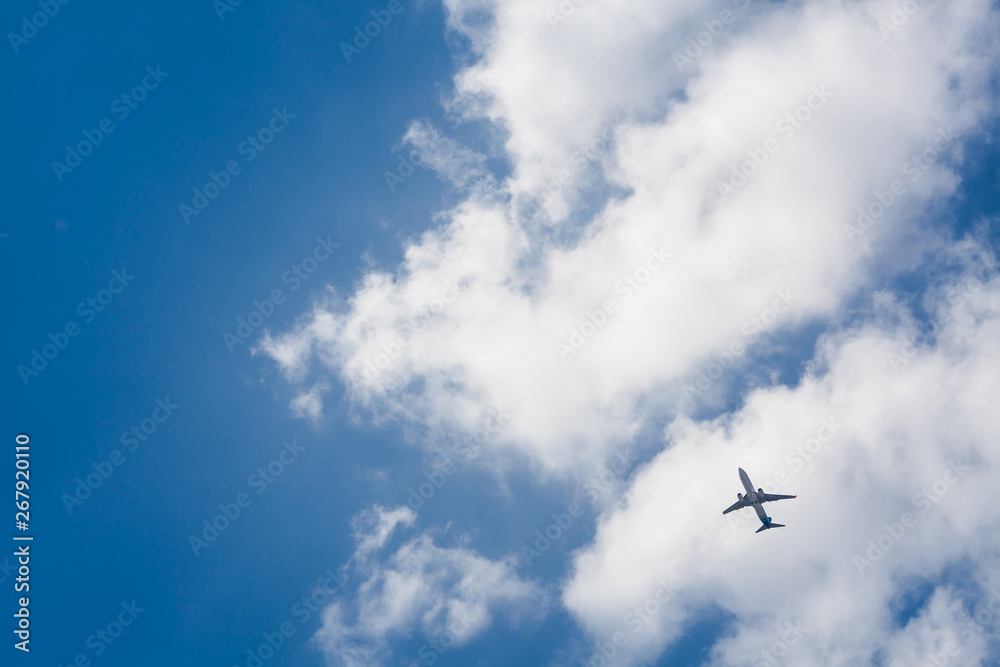 Flying plane on a background of blue sky and clouds