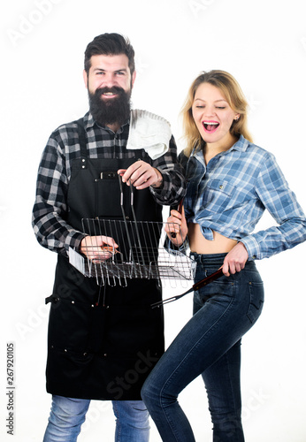 Family weekend. Couple in love hold cooking utensils for barbecue. Tools for roasting meat outdoors. Picnic and barbecue. Culinary concept. Man bearded hipster and girl ready for barbecue party