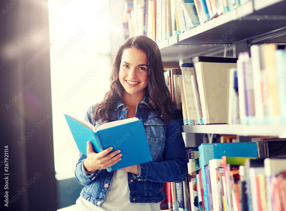 education, high school, university, learning and people concept - smiling student girl reading book at library education, high school, university, learning and people concept - smiling student girl reading book at library