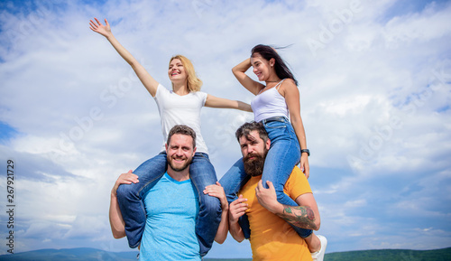 They are fun to be with. Loving couples having fun activities outdoor. Happy men piggybacking their girlfriends. Loving couples enjoy fun together. Playful couples in love smiling on cloudy sky