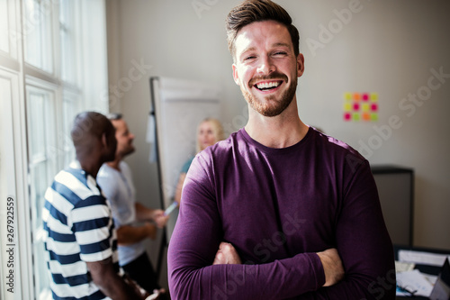 Laughing young designer standing in an office after a presentati photo