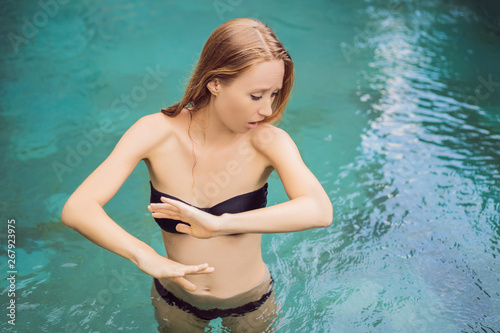 Frustrated young woman having a bad skin in the pool. Due to the fact that chemicals in the pool photo