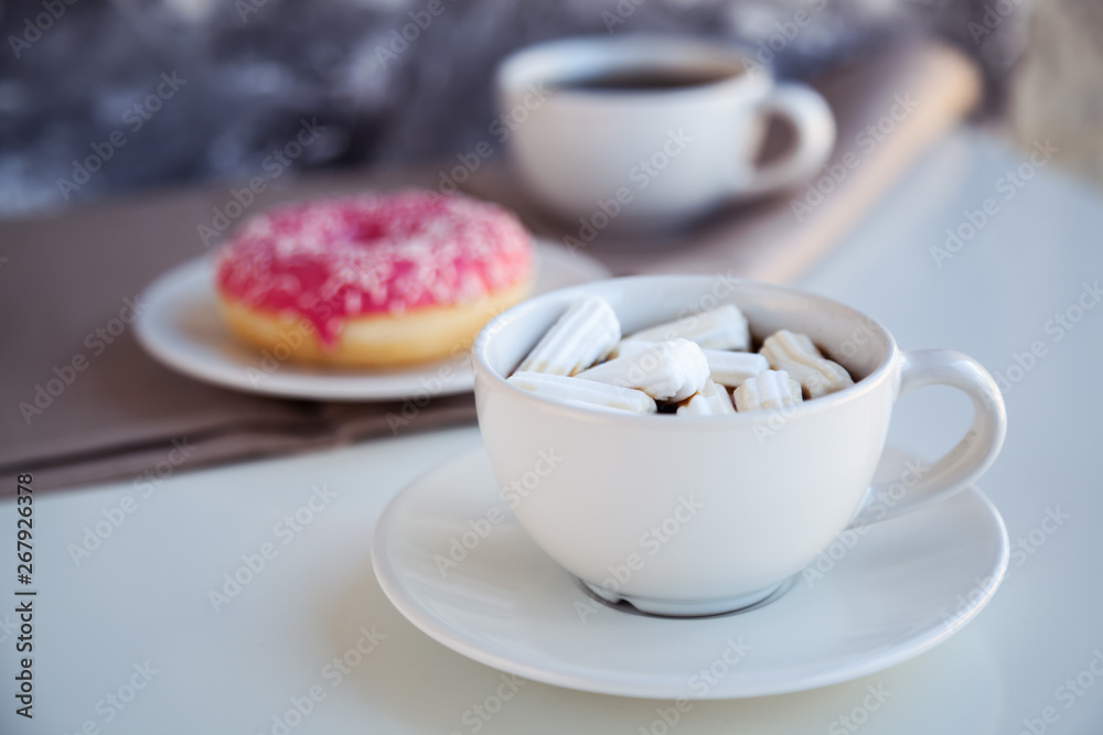 Black coffee with glazed donuts and marshmallow. Pink tasty donut on a table. Morning breakfast.