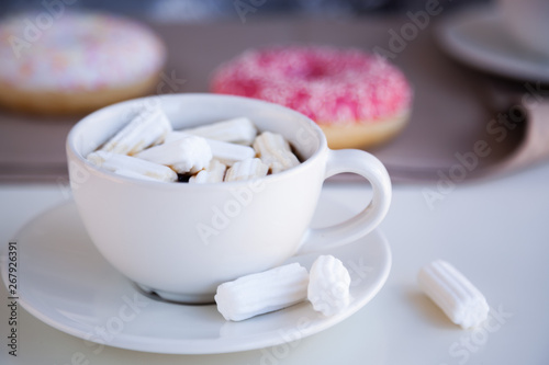 Black coffee with glazed donuts and marshmallow. Pink tasty donut on a table. Morning breakfast.